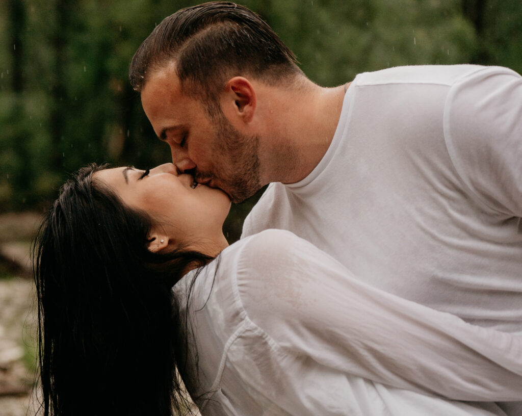 Couple kissing outdoors in the rain.