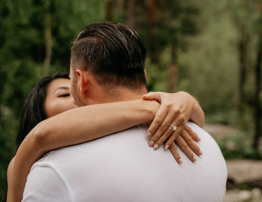 Couple kissing, engagement ring visible