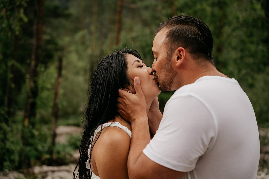 Couple sharing a tender kiss in nature.