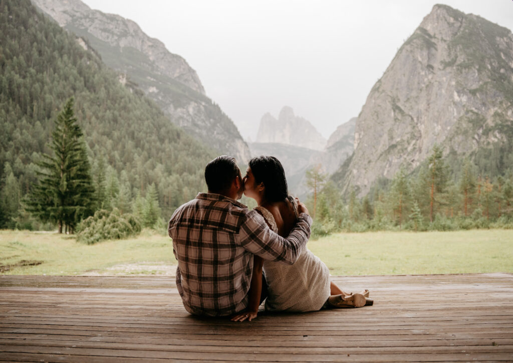 Couple kissing with mountain view backdrop.