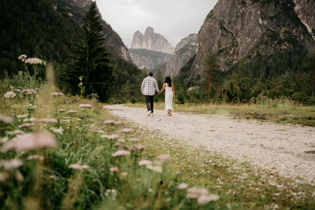 Couple walking on mountain path, scenic backdrop