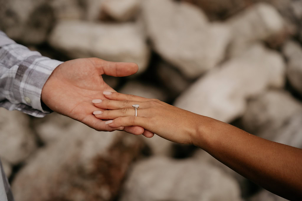 Engagement ring on hand holding partner's hand