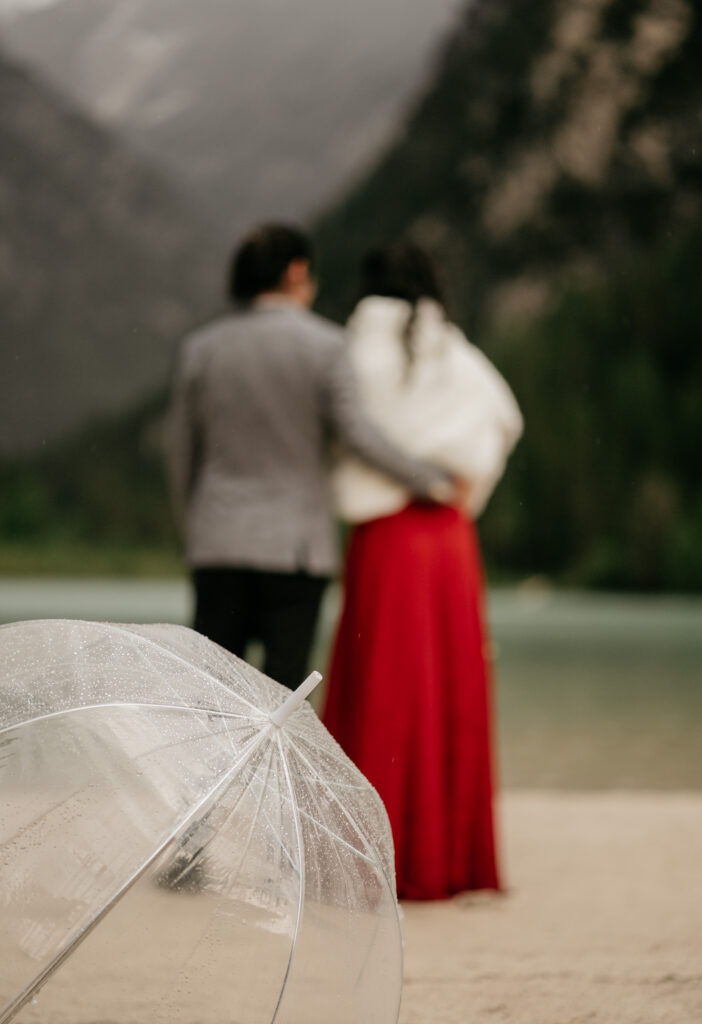 Couple with umbrella at scenic lakeside