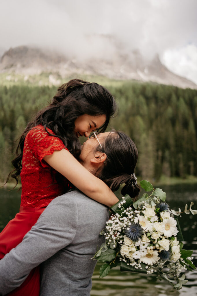 Couple embracing in a scenic outdoor setting.