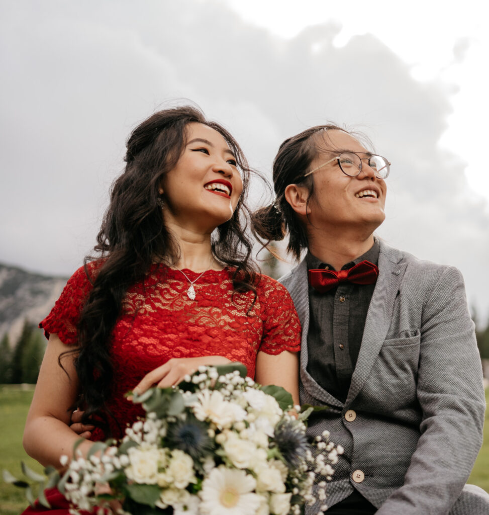 Happy couple smiling outdoors with bouquet