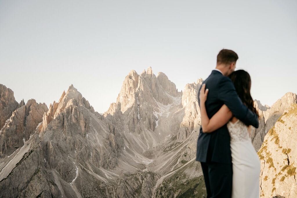 Couple embracing in front of rocky mountain landscape.