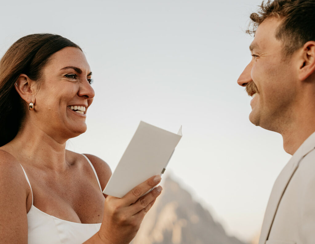 Smiling couple exchanging vows outdoors.