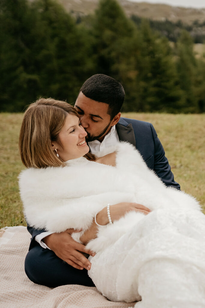 Couple embracing outdoors in elegant clothing.