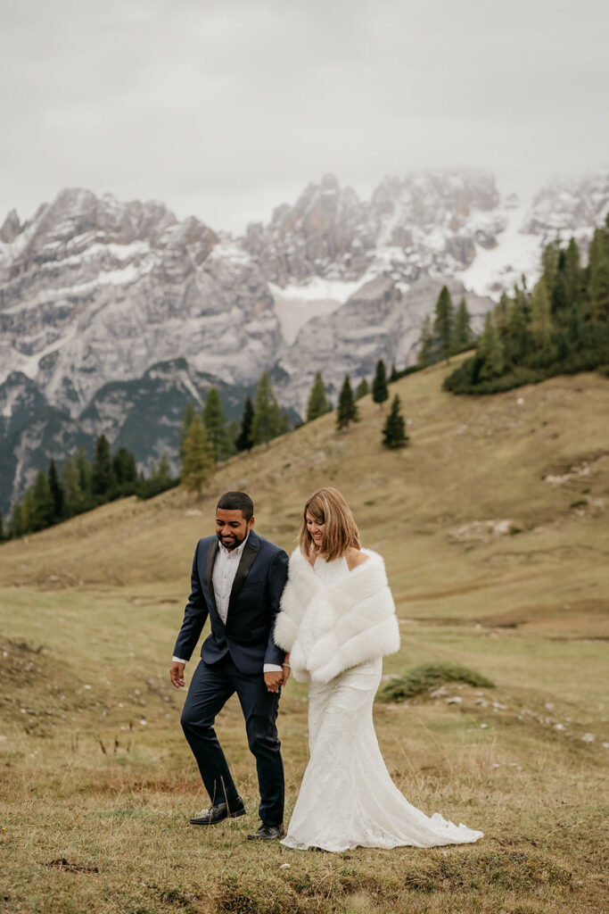 Couple in wedding attire walking in mountains