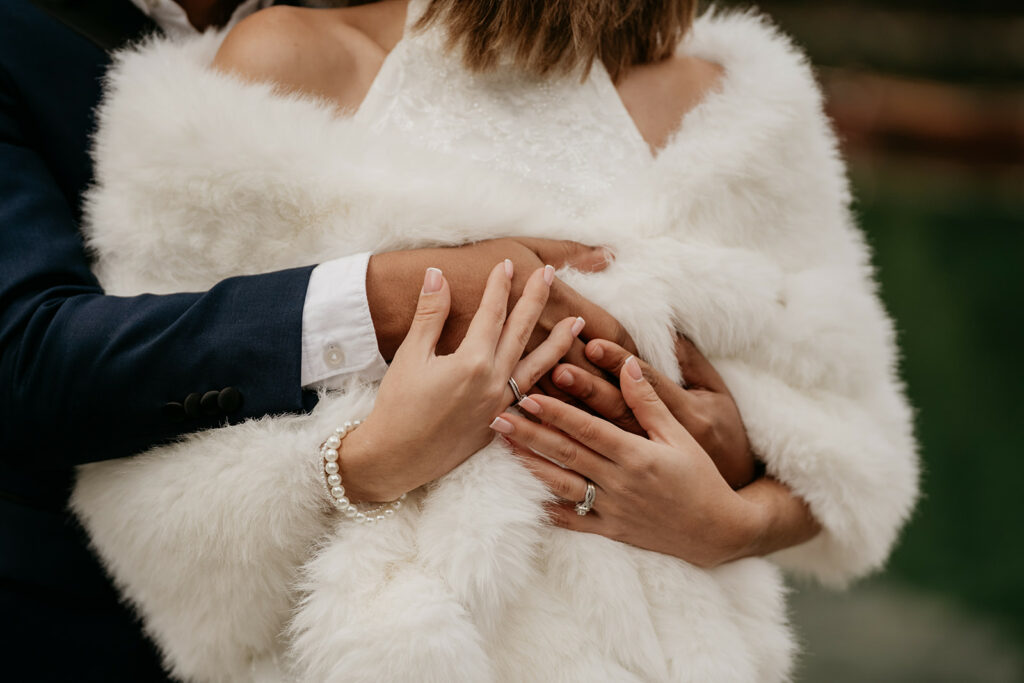 Couple embraces in elegant wedding attire.