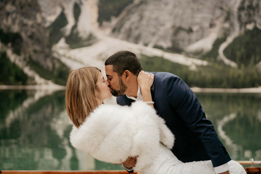Couple kissing by a scenic lakeside