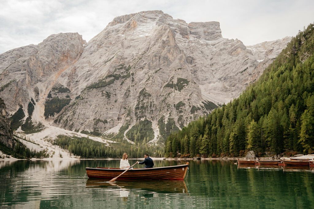 Rowboat on mountain lake with forest view.