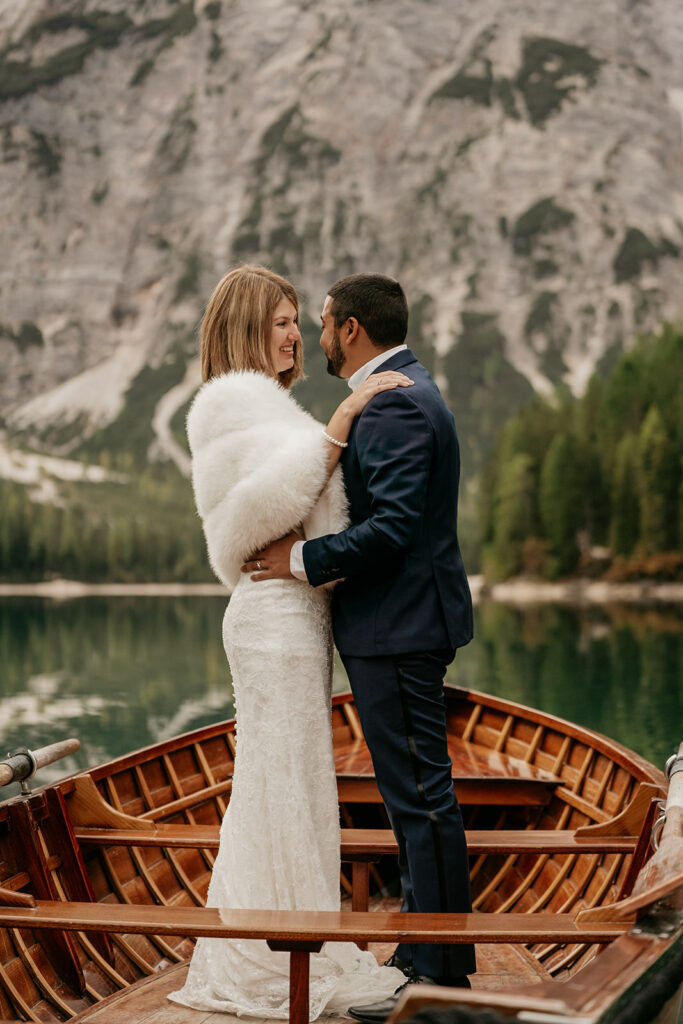 Bride and groom embrace on a boat.