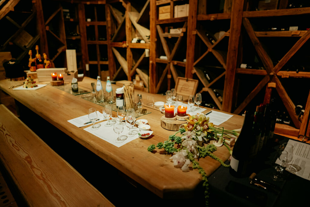 Wine cellar dining table with candles and glasses.