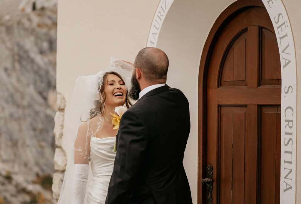 Bride laughing, groom fixing her veil