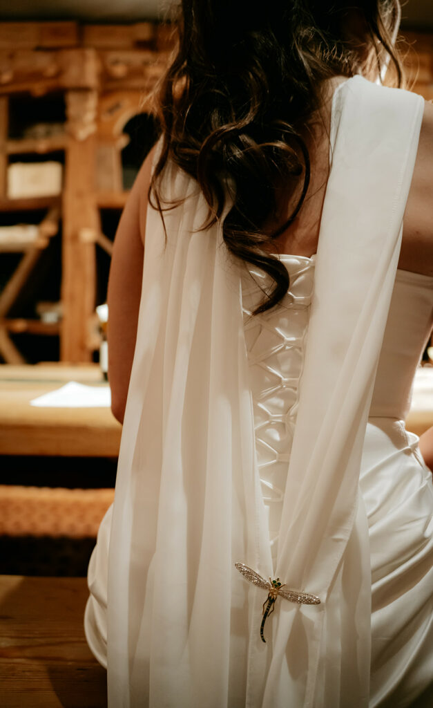 Back of white dress with dragonfly brooch