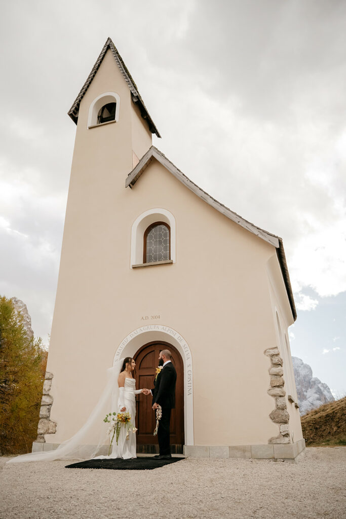 Bride and groom outside a small chapel.