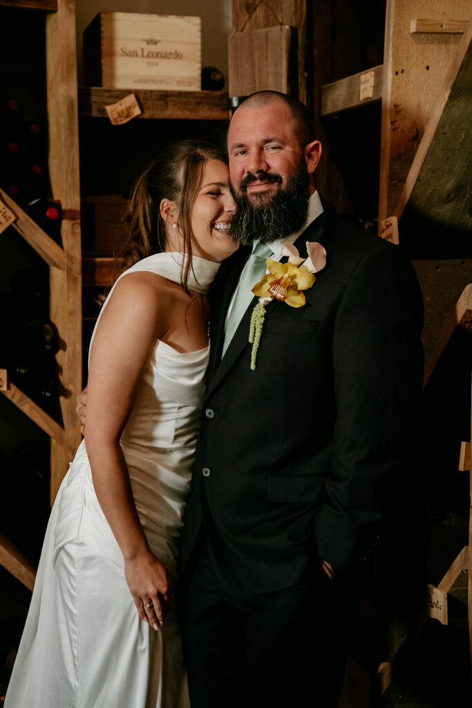Smiling bride and groom in wine cellar