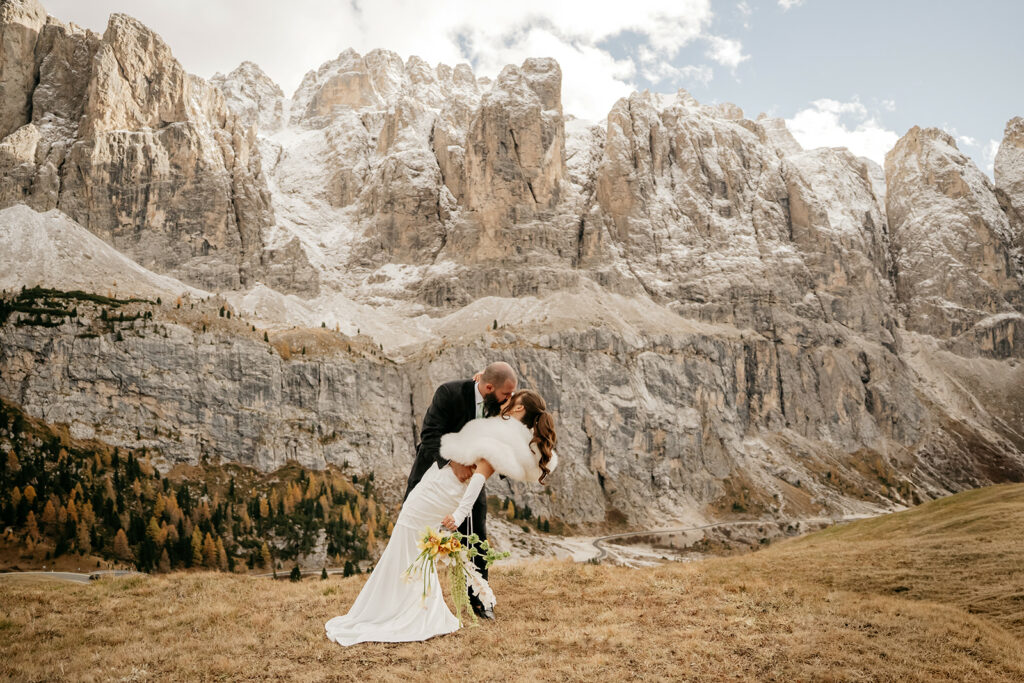 Couple kissing in mountain landscape wedding photo.
