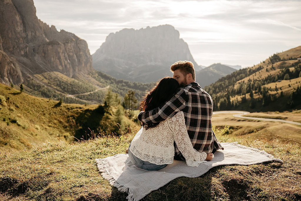 Couple embracing on hillside with mountain view