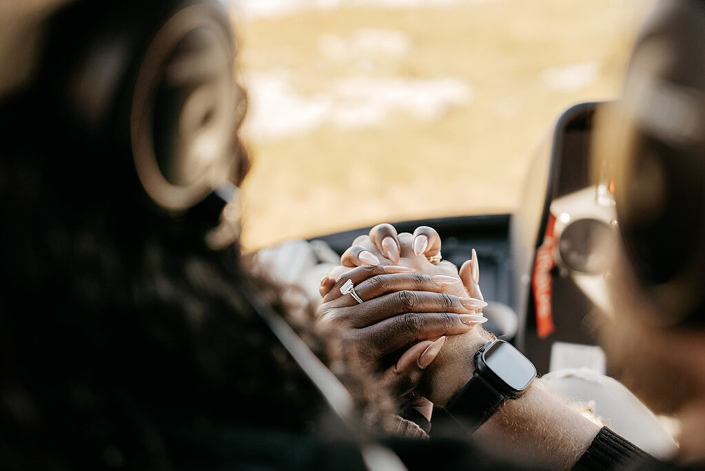 Couple holding hands in helicopter cockpit