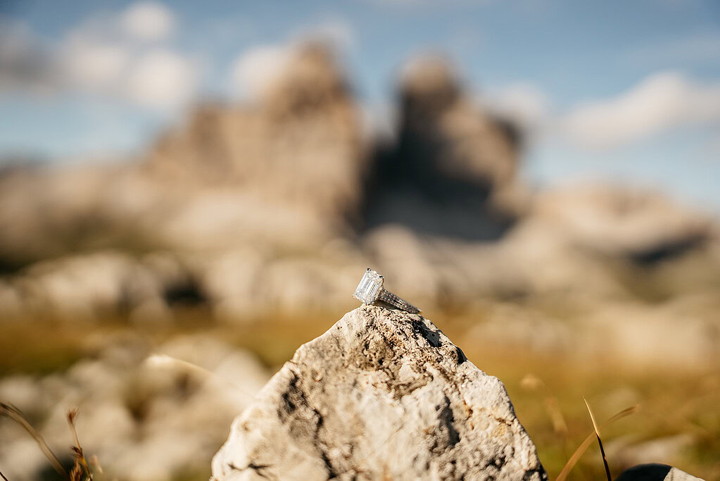 Diamond ring on a rock, mountain background.