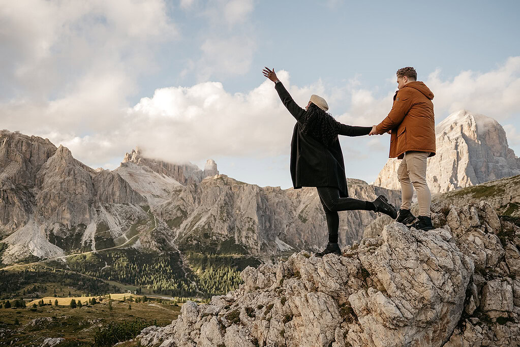 Couple on mountain, enjoying scenic view.