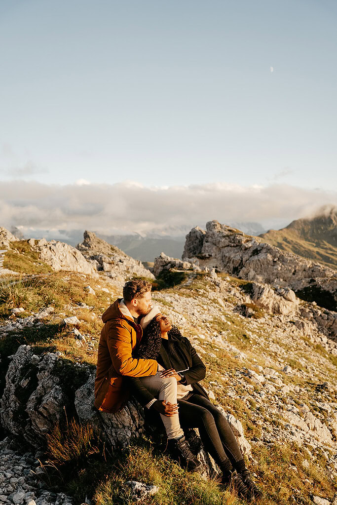 Couple cuddling on scenic mountain landscape