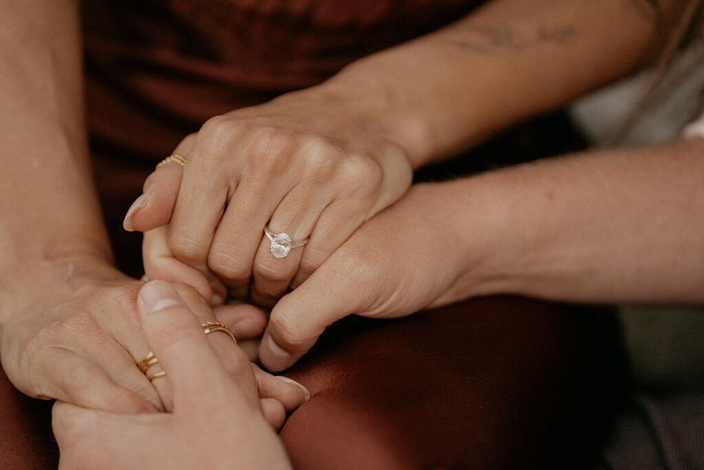 Hands holding with engagement ring visible