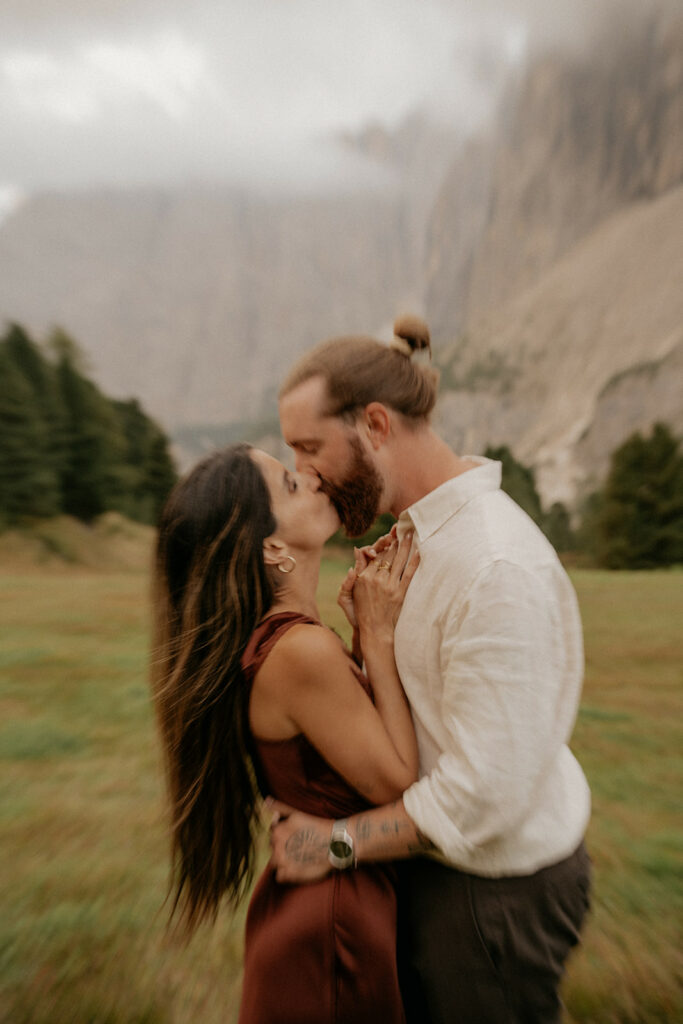 Couple kissing in misty mountain landscape
