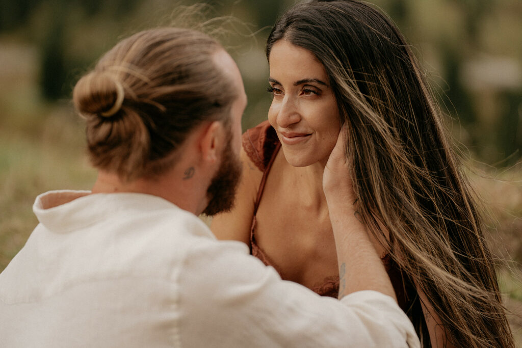 Couple gazing lovingly at each other outdoors.