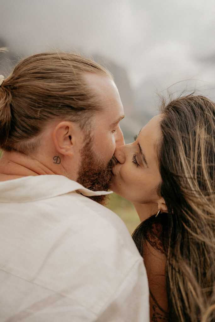 Couple sharing a tender kiss in nature.