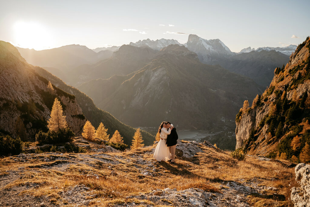 Couple embracing on mountain at sunset.