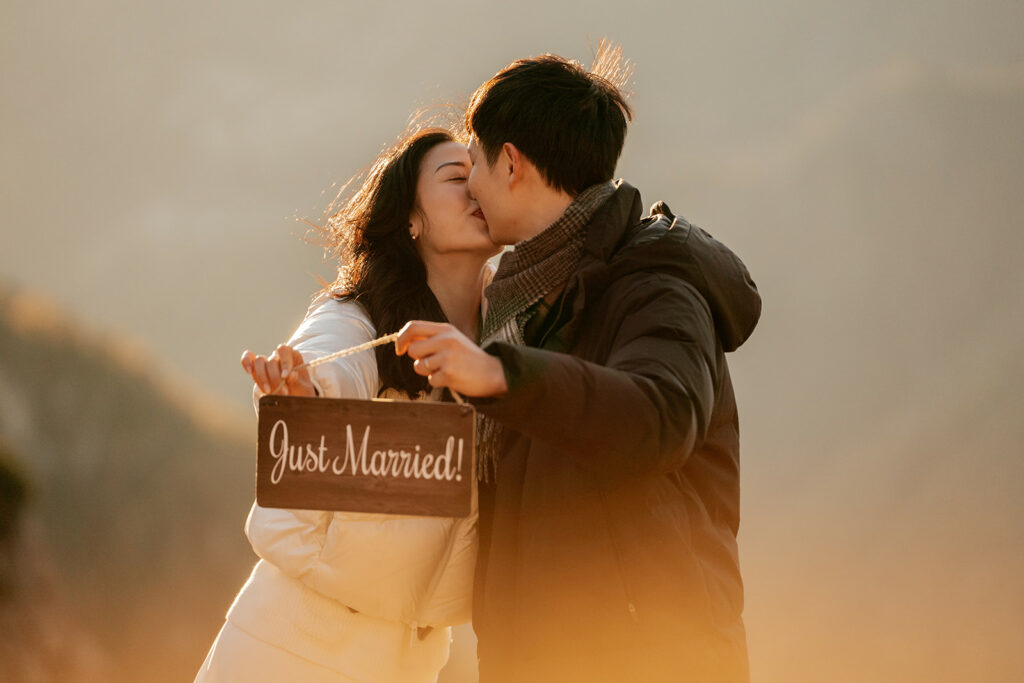 Couple kissing with 'Just Married' sign.