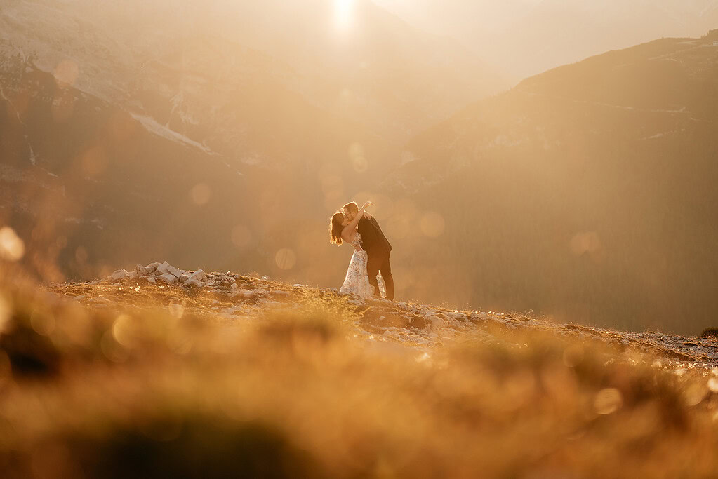 Couple kissing on sunny mountain landscape