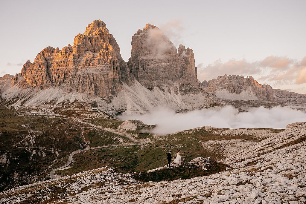 Bride and groom in front of mountain landscape.