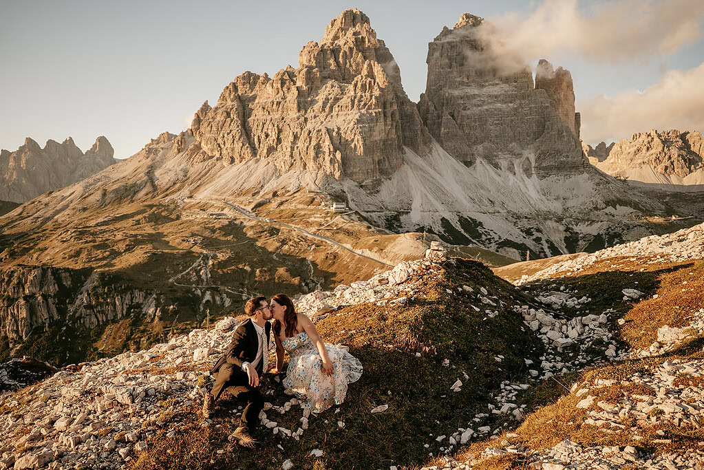 Couple sitting near mountains in sunset light