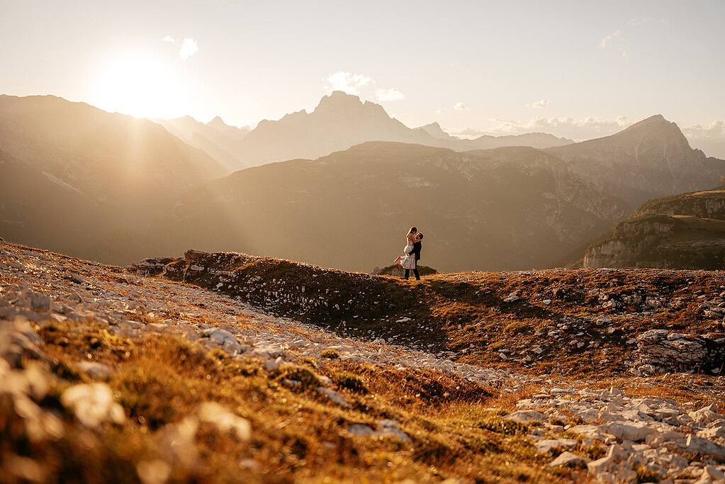 Couple embracing on mountain at sunset