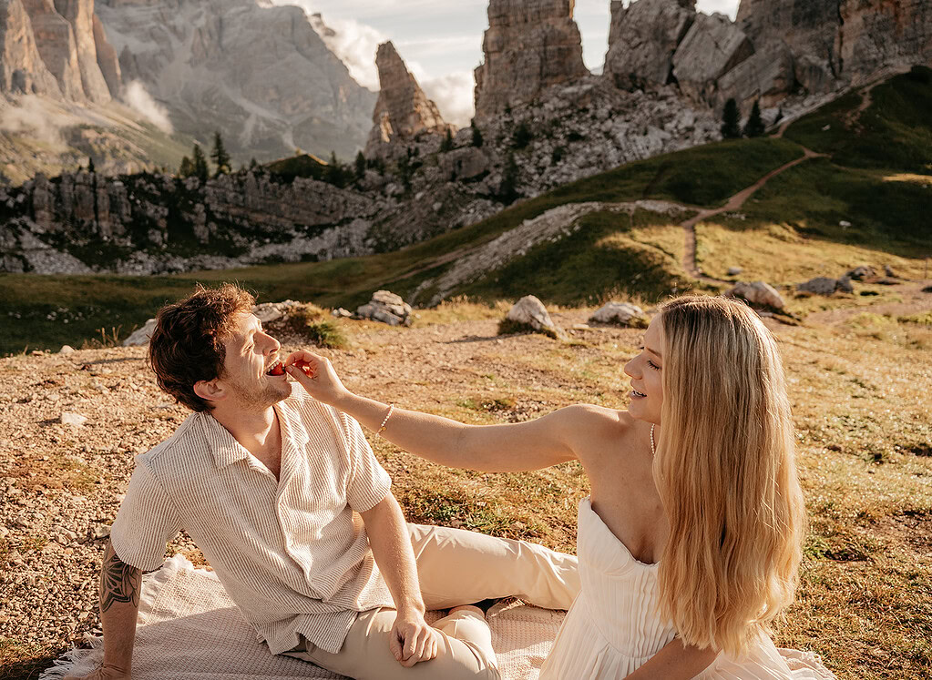 Couple enjoying picnic with mountain view.