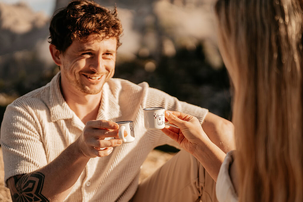 Couple enjoying coffee outdoors with smiles