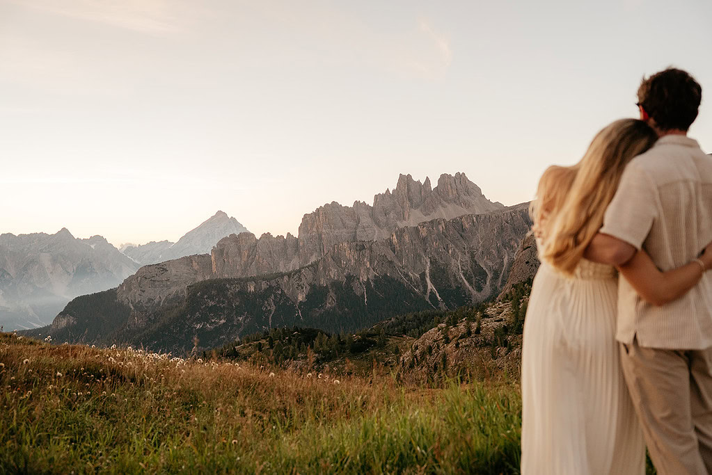 Couple embraces with mountain view at sunset