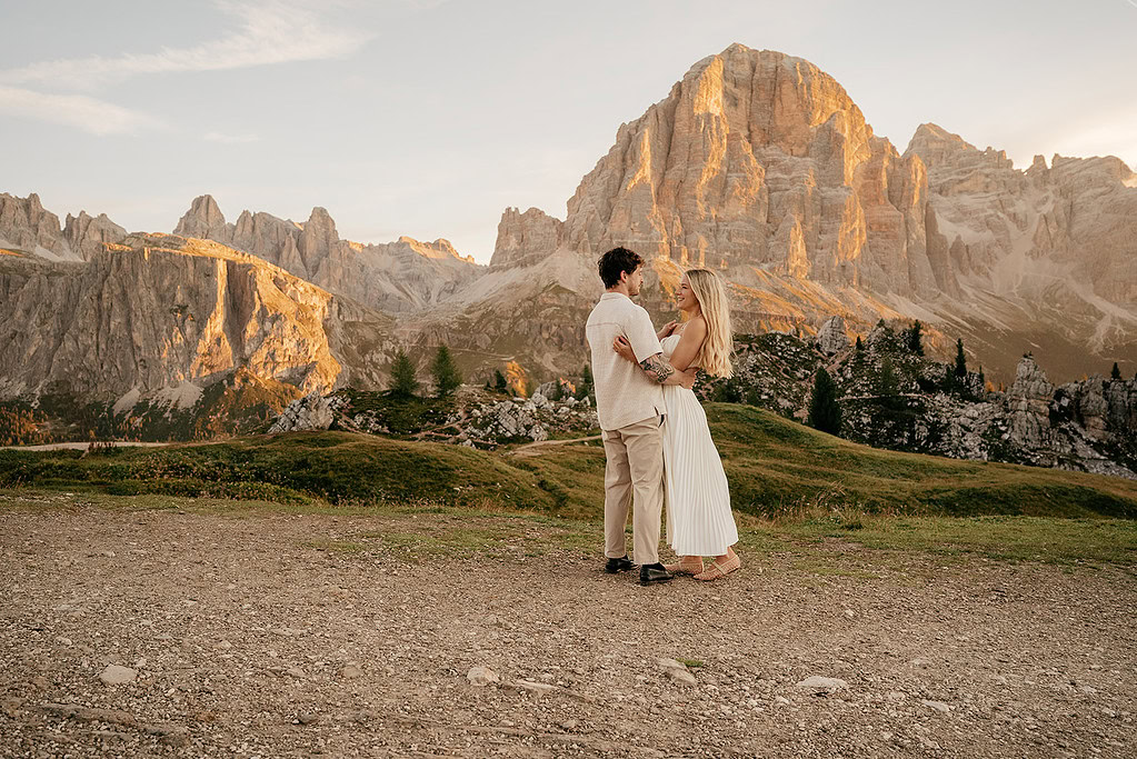 Couple embracing in scenic mountain landscape at sunset.