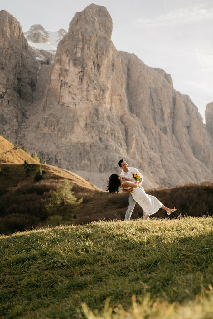Couple dancing in front of dramatic mountain backdrop.