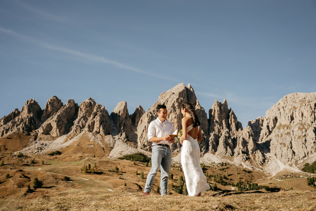 Couple stands before rocky mountain landscape