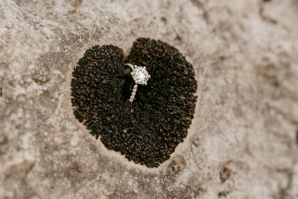 Diamond ring in heart-shaped indentation on rock