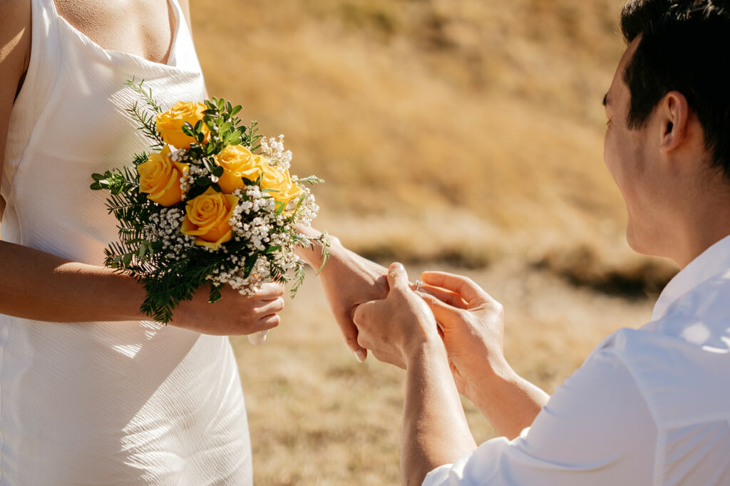 Man proposing with engagement ring outdoors.