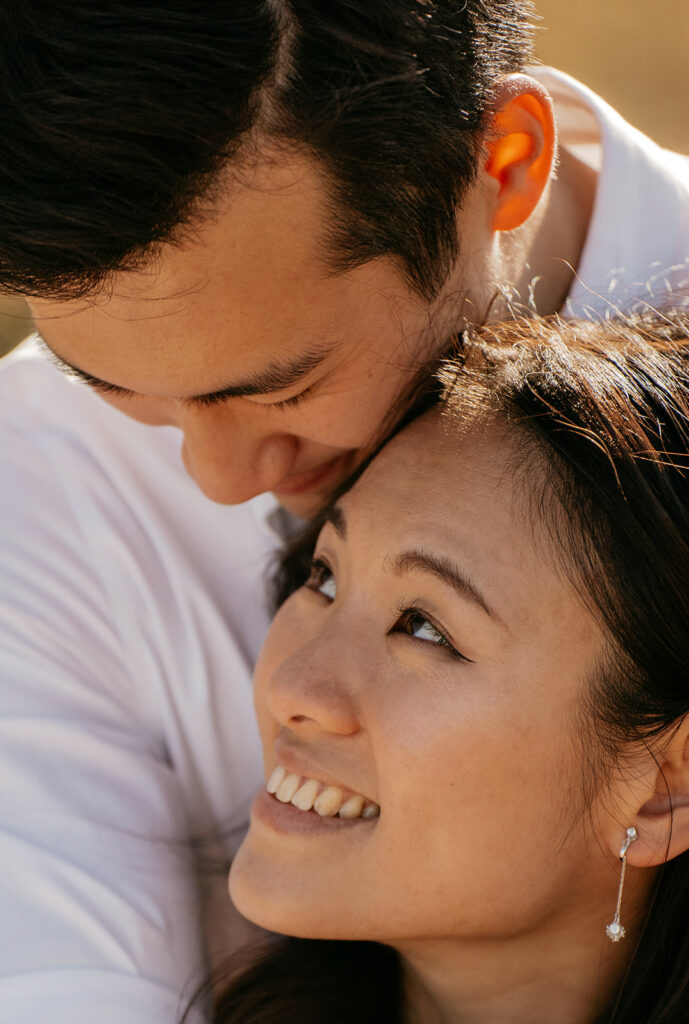 Couple embracing with smiles in sunlight.
