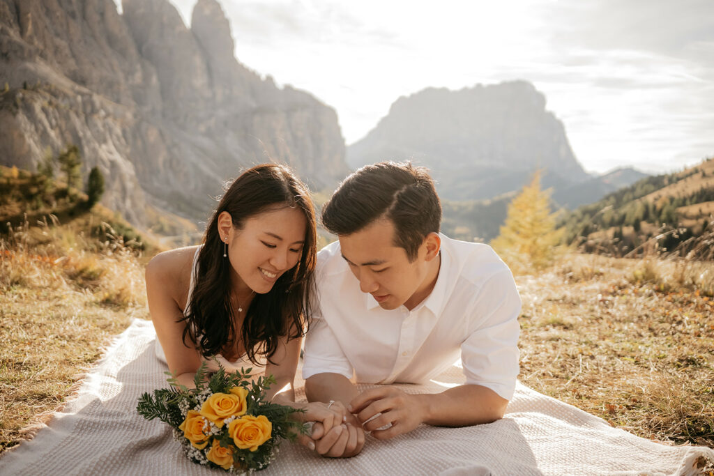 Couple laying on picnic blanket in mountain landscape