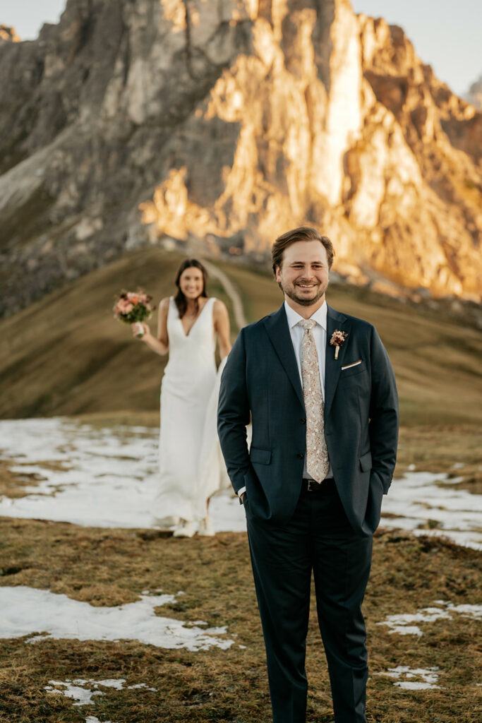 Bride and groom in mountain landscape at sunset.