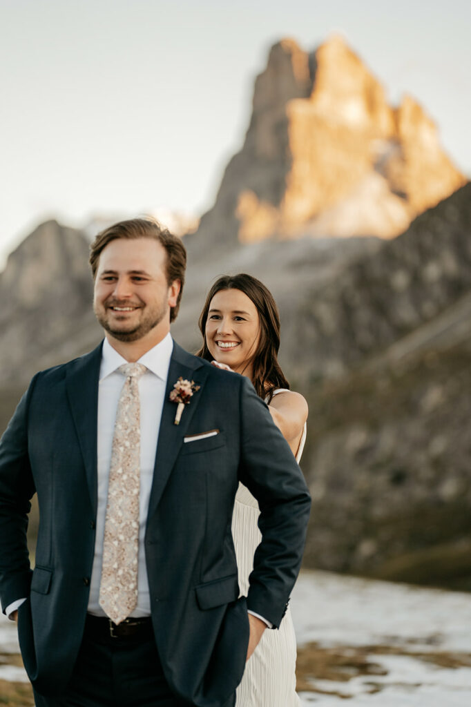 Smiling couple in mountainous landscape, wedding attire